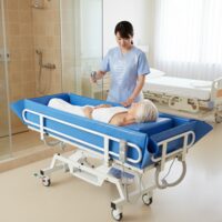 Pat electric pentru duș și transfer pacienți Moretti BI110, reglabil 59–99 cm, capacitate 200 kg